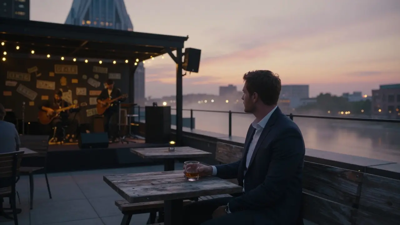Groom sitting quietly on a Nashville rooftop at dawn with a bourbon glass as a band plays softly.